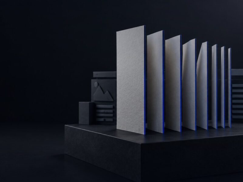 A blank paper banknote cut into upright strips of different widths in front of website layout blocks, a metaphor for where a web design budget goes